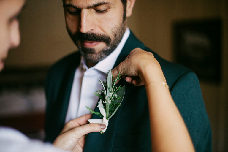 Groom putting on boutonnière