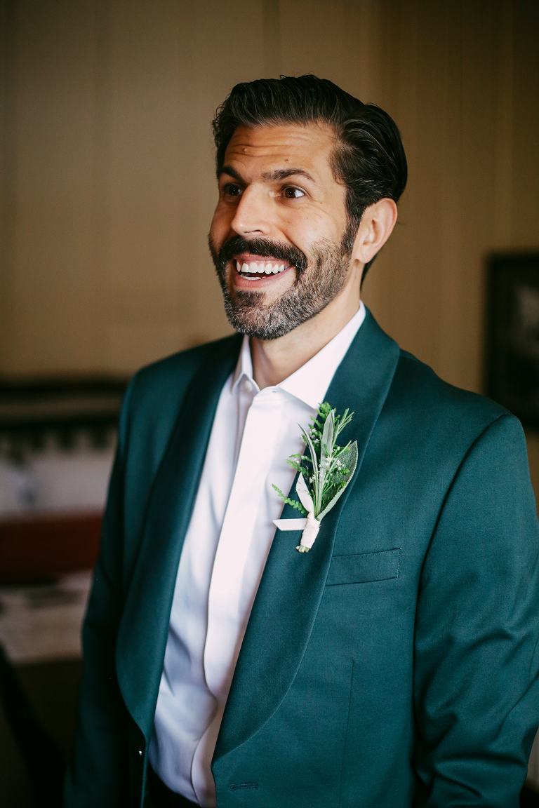 Groom putting on boutonnière