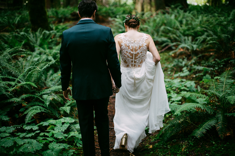 Bride and groom walking through the woods