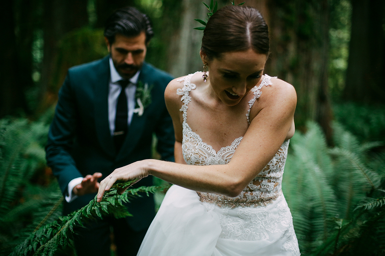 Bride and groom walking through ferns