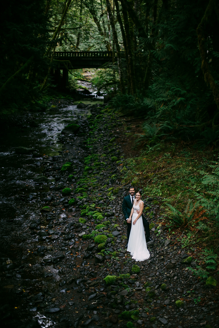 Bride and groom along a creek
