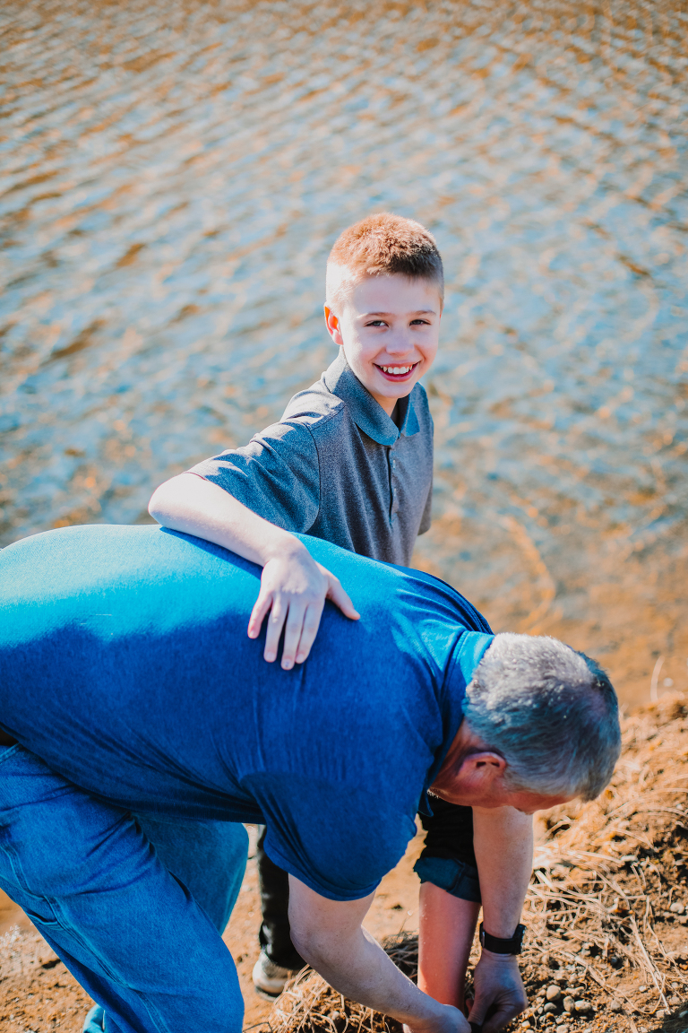 Dad helps clean off his son's feet after playing in the water. 