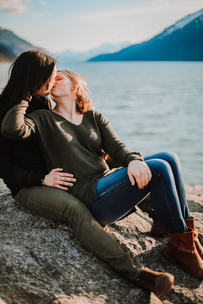 A portrait of a beautiful lesbian couple kissing one another at Yakutania Point.