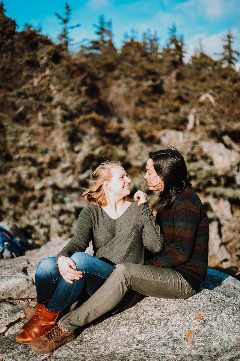 A beautiful lesbian couple sitting on the rocks at Yakutania Point.