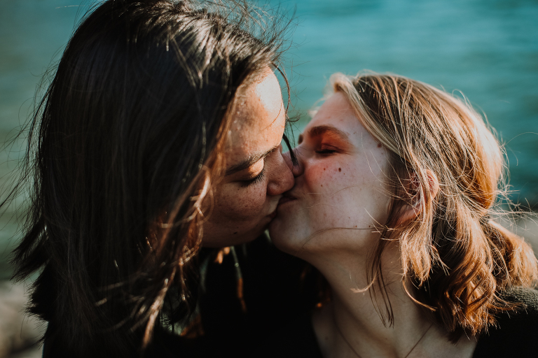 A beautiful lesbian couple kissing one another at Yakutania Point.