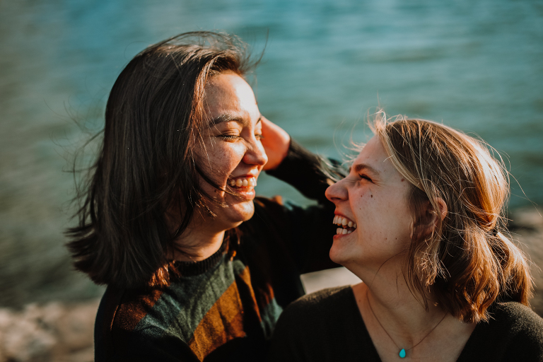 A young lesbian couple laughing together Yakutania Point.