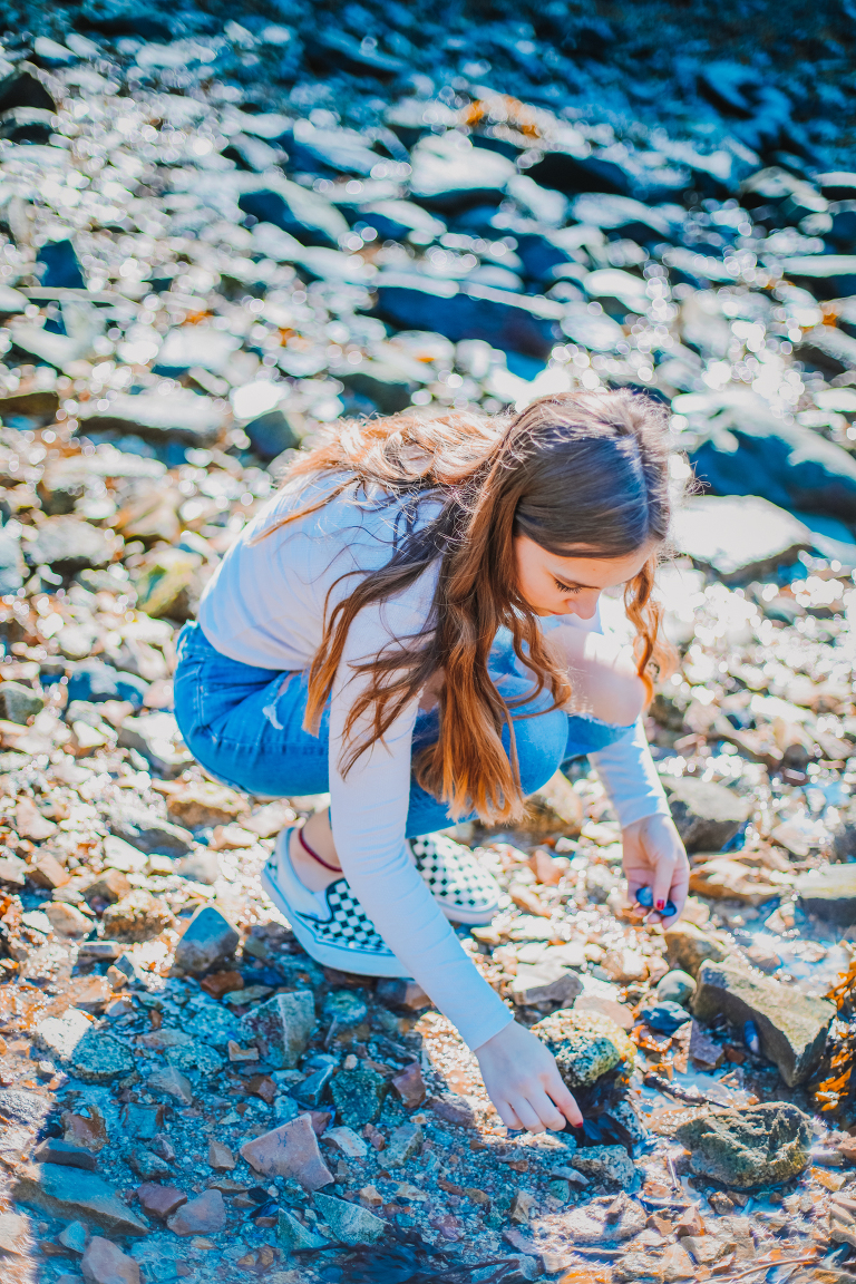 Daughter looks for shells along the beach. 