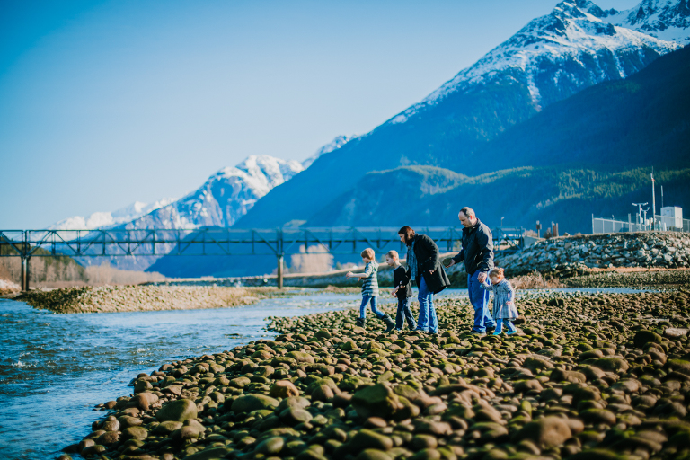 A family walks along the rocks in a small mountain town. 