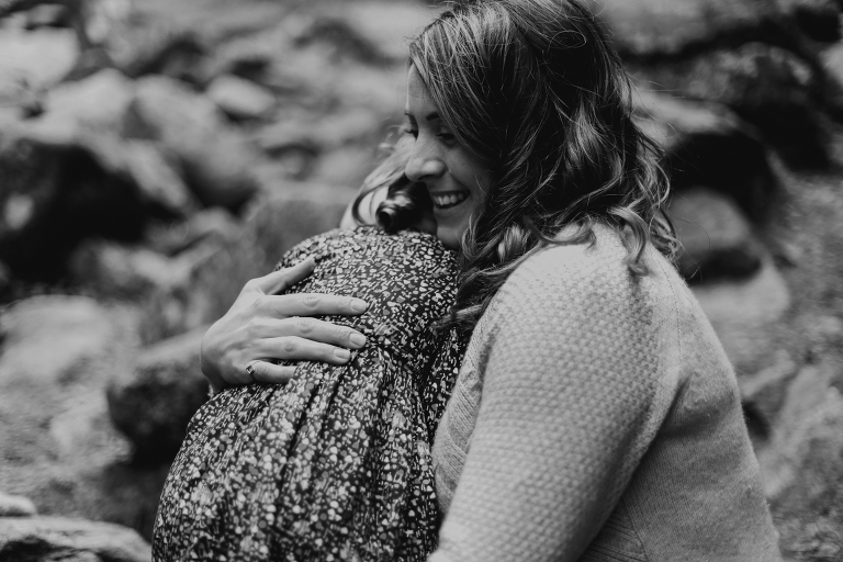 Mom embraces her daughter in this black and white photo. 