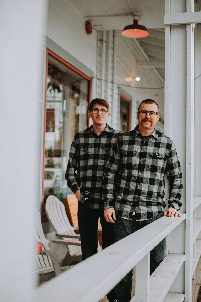 Father and son stand in matching shirts on the front porch of the Vashon Coffee Roasterie.