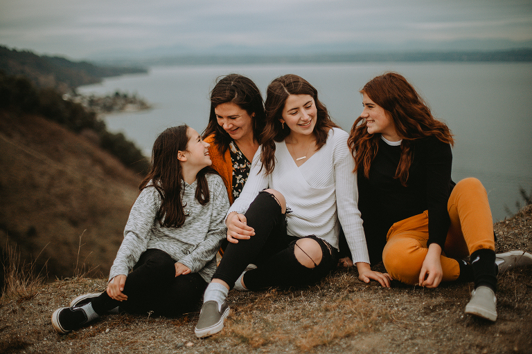 The Myers girls sit on a sandy cliff looking out over the ocean on Vashon. 