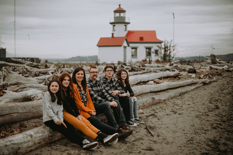 The Myers Family sits on a log in front of the Point Robinson lighthouse on Vashon. 
