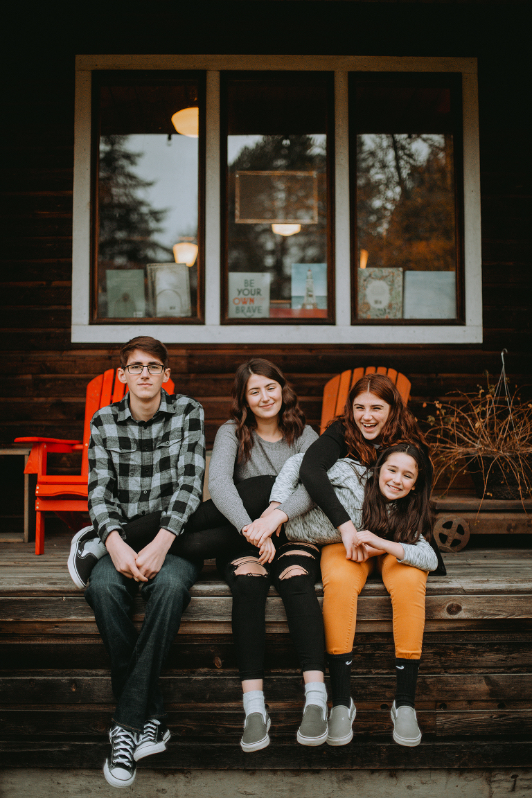 The Myers siblings pose on the porch of the Country Store, with their youngest sister laying across their laps. 