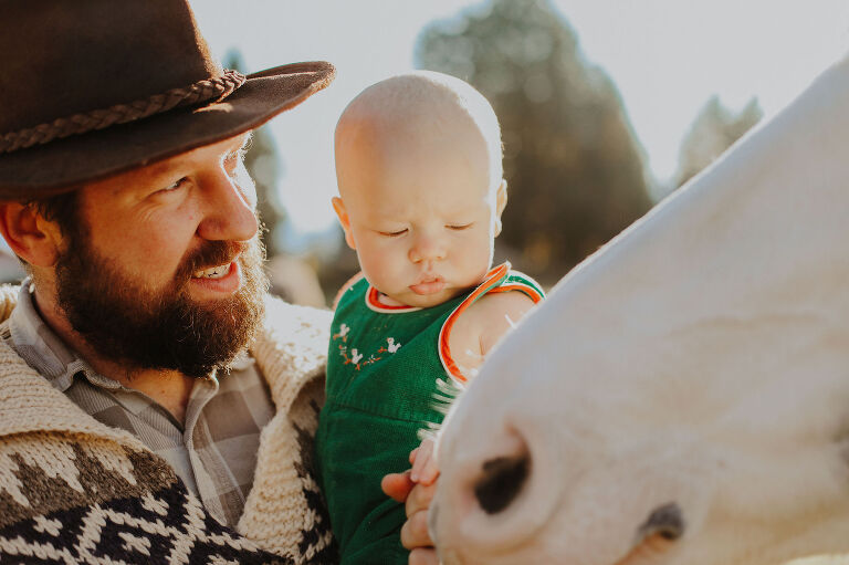 Dad and baby get up close and personal with a horse. 