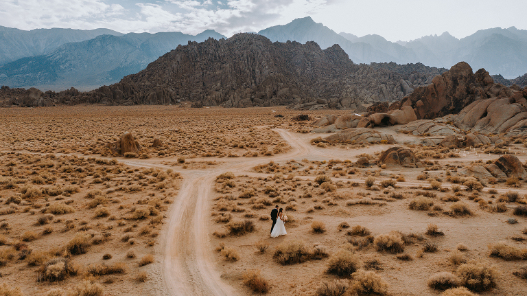 A drone photo of the bride and groom walking toward their ceremony in Alabama Hills.