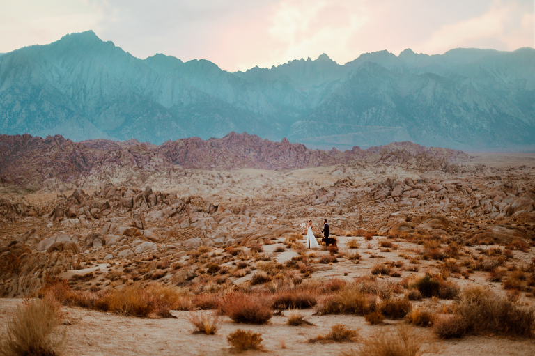 Paul and Kristi walk down movie road in Alabama Hills with Wiley. 