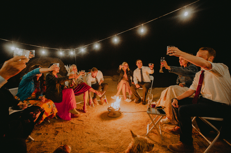 The wedding party shares a toast over the fire during their Alabama Hills reception. 