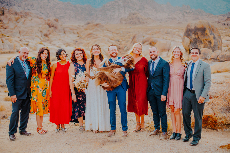 Paul and Kristi pose with their entire wedding party, holding Wiley for a photo.